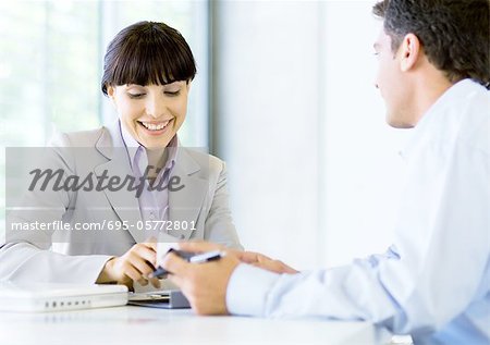 Homme et une femme jouissant de discussion dans le bureau
