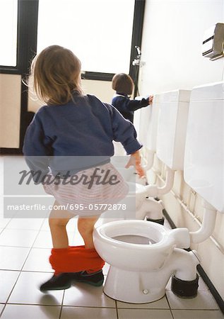 Little girl next to children's toilet with panties around ankles, rear  view, other toilets and child in background. - Foto de stock - Masterfile -  Royalty Free Premium, Número: 695-05772878