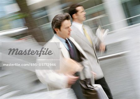 Two businessmen walking outside, blurred motion