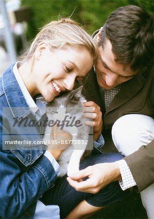 Man and woman holding cat, close-up