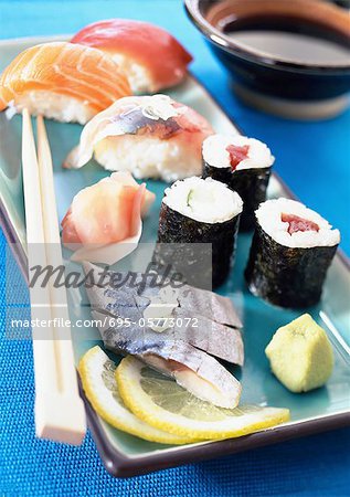 Various types of sushi on plate with chopsticks, close-up