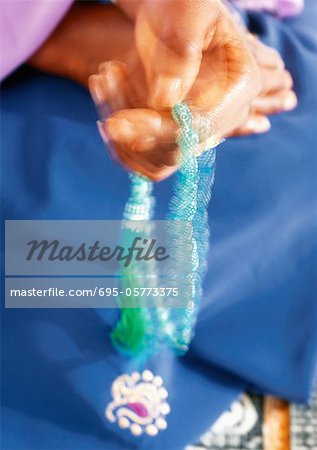 Close up of woman's hands holding prayer beads