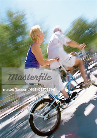 Homme mûr et femme cheval ensemble sur vélo tandem, floue