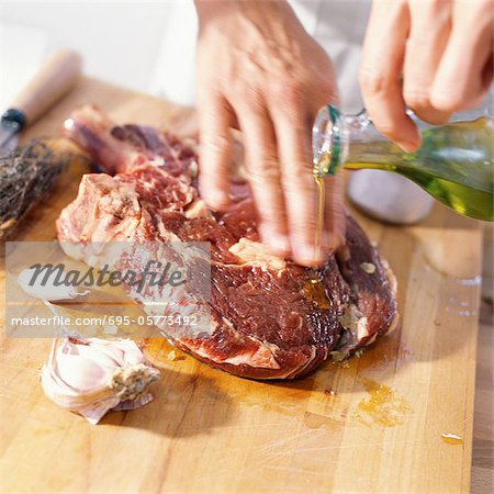 Gros plan de ribeye steak en préparation avec de l'huile