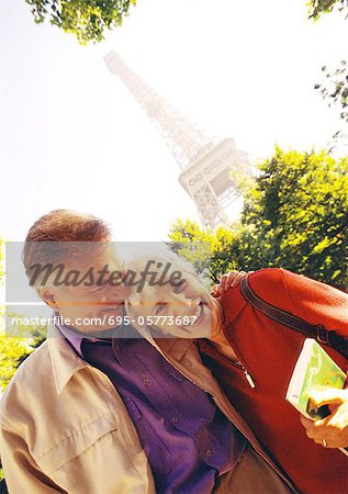 France, Paris, mature femme et homme souriant, la tour Eiffel en arrière-plan, portrait