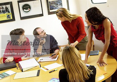 People in conference room, gathered around table