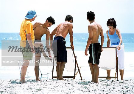 Family arranging chairs on beach