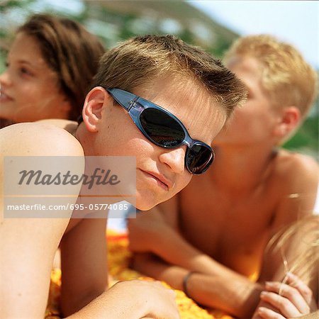 Boy wearing sunglasses, friends in background