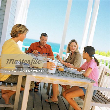 Couple and children having breakfast outside