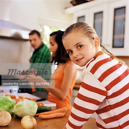 Family cooking, little girl looking over shoulder