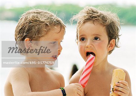 Deux jeunes enfants, partage des sucettes glacées, portrait, tête et épaules.