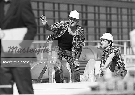 Builders with hard hats, talking, b&w