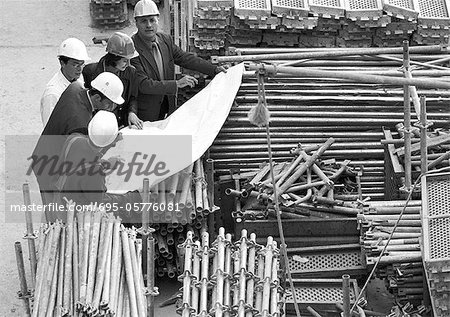 Cinq personnes examinant des projets en chantier, b&w