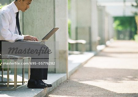 Homme d'affaires sur le banc avec ordinateur portable