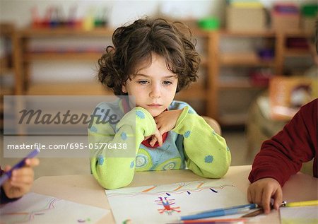 Child sitting at table, head and shoulders