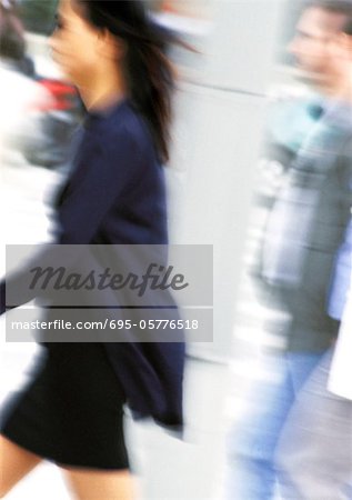 Businesswoman walking, side view, blurred