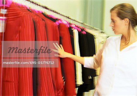 Woman looking at jackets in clothing store.