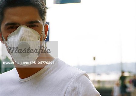 L'homme de porter un masque anti-poussière blanc sur le nez et la bouche, arrière-plan flou