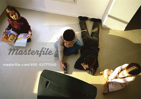 Jungen und Mädchen sitzen auf dem Boden vor dem Fernseher, erhöhte Ansicht