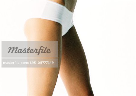 Jeune femme portant des culottes blanches, abdominaux