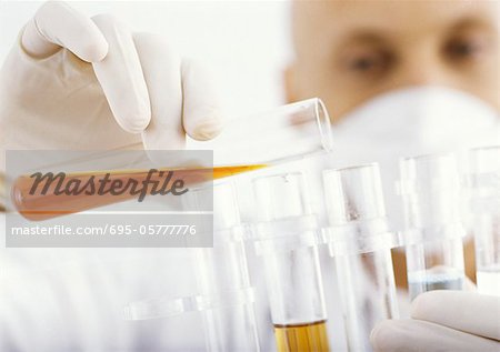 Man transferring contents of test tube