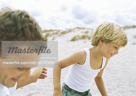Boy und Vater betreiben am Strand
