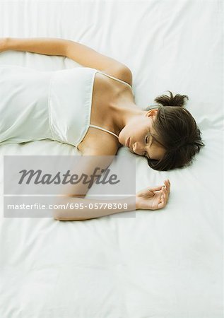 Jeune femme allongée sur le lit