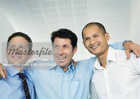 Three businessmen with arms around each others' shoulders