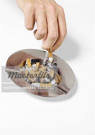 Hand putting out cigarette in ashtray