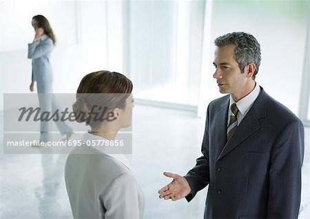 Businessman and businesswoman having discussion in lobby