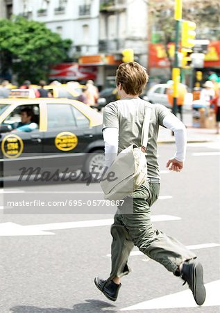 Young man running across street