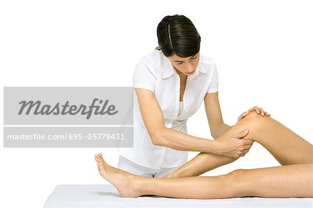 Femme donnant le massage de jambe, recadrée vue des jambes