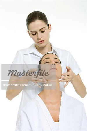 Massage thérapeute donnant cou massage pour femme avec sa tête en arrière et les yeux fermés
