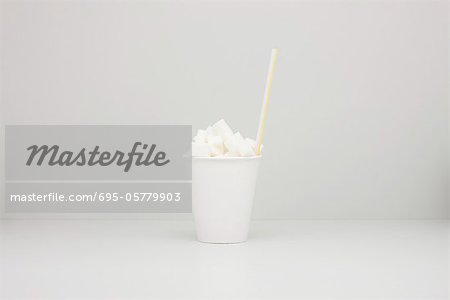 Food concept, disposable cup filled with sugar cubes Food concept, disposable cup filled with sugar cubes