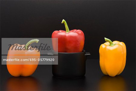Fresh bell peppers, one squeezed into miniature pot