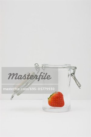 Food concept, single fresh strawberry in glass gar