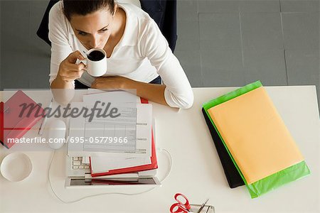 Geschäftsfrau am Schalter aktuelle bei einer Tasse Kaffee