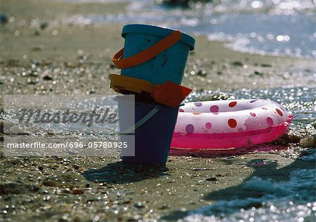 Buckets and inflatable ring on beach