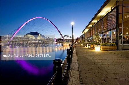 Blick entlang der Newcastle Quayside in der Nacht am Fluss Tyne, das Flutlicht Gateshead Millennium Bridge, die Arched Bridge und die Sage Gateshead, Newcastle upon Tyne, Tyne and Wear, England, Vereinigtes Königreich, Europa