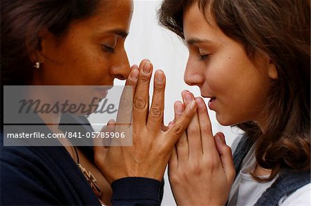 Mutter und Tochter beten zu Hause, Paris, Frankreich, Europa