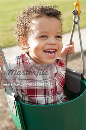 Close-up Portrait du jeune garçon au Swing au terrain de jeux