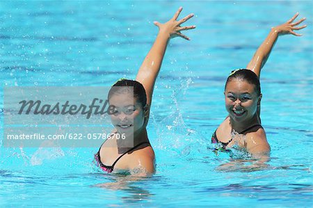 Synchronized Swimmers Performing in Swimming Pool