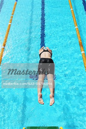 Jeune femme plongée dans la piscine