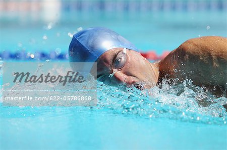 Jeune homme nage dans la piscine