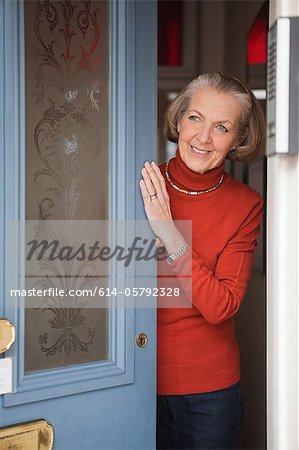 Senior woman opening front door