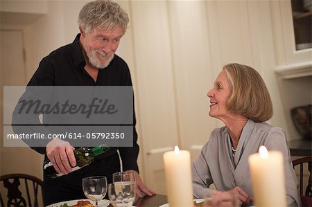 Man pouring wine for wife