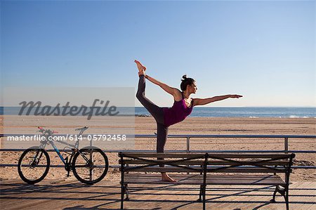 Frau in Yoga-Pose auf promenade