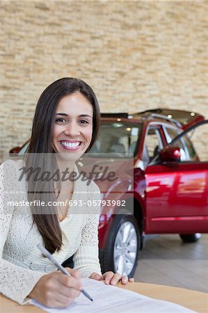 Portrait of smiling young woman signing agreement