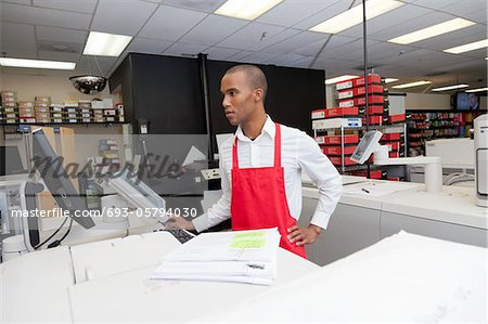 Manual worker looking at cash register machine