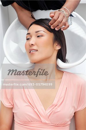 Asian woman having hair wash at beauty salon